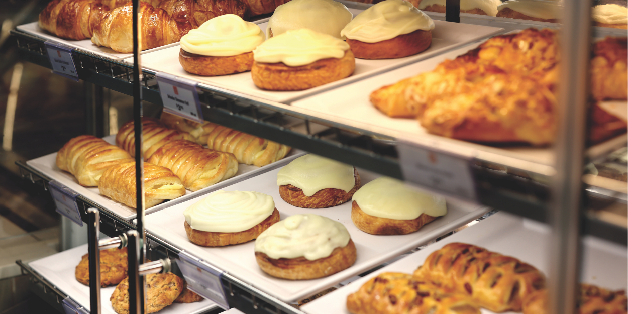 Display case with various pastries including croissants and cakes.