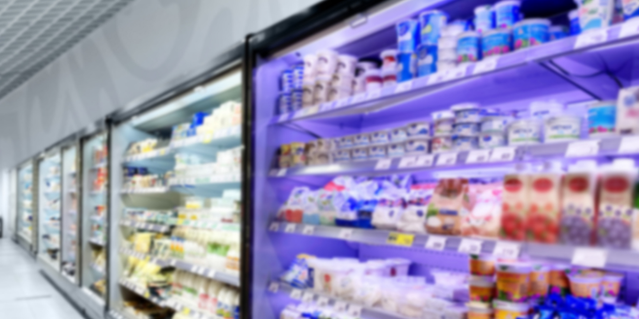 Cold food items in open air refrigerated merchandisers in a grocery store.