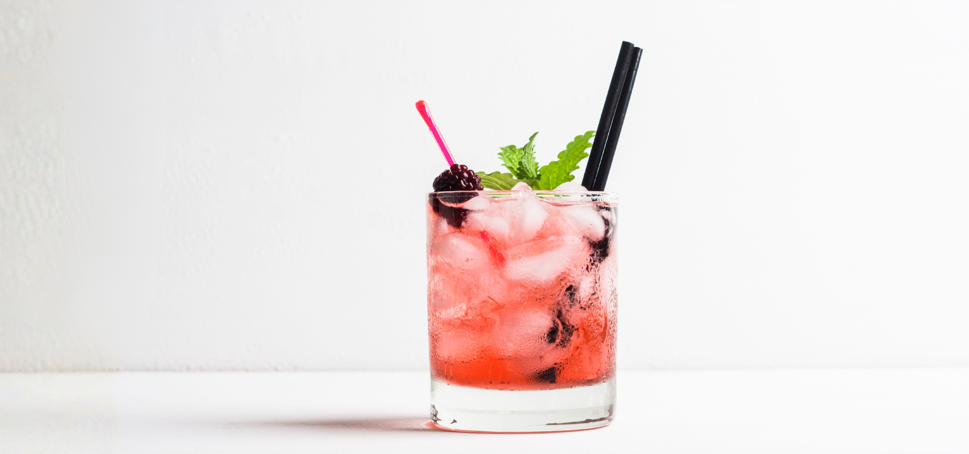 Cocktail with ice, cherry, and mint on a white background