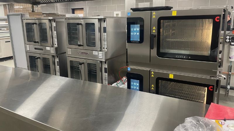 School kitchen with stacked convection and combi ovens for high-volume meal preparation