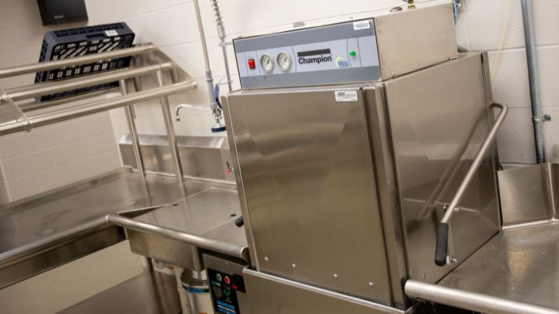 Commercial dishwashing machine with pre-rinse station in school cafeteria kitchen