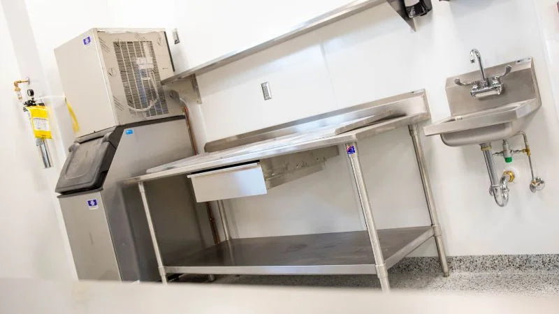 Stainless steel prep table with built-in hand sink next to ice machine