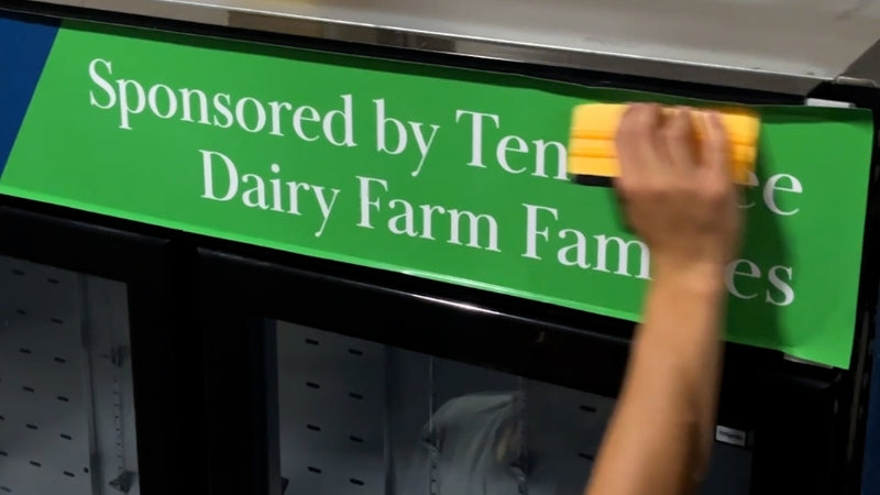 The Dairy Alliance wrap being applied on Atosa merchandiser refrigerator