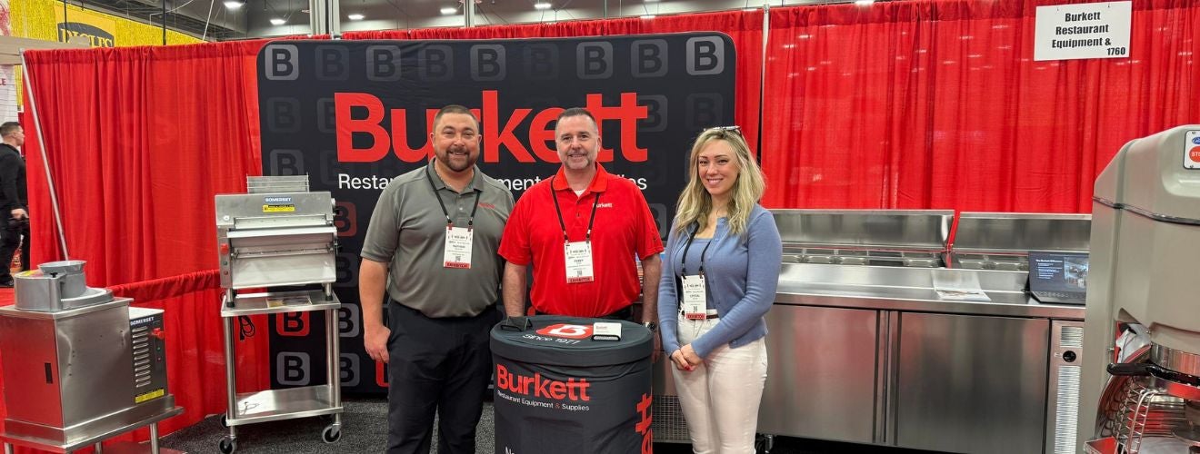 Burkett team members Nathan, Perry, and Crystal in the Burkett booth