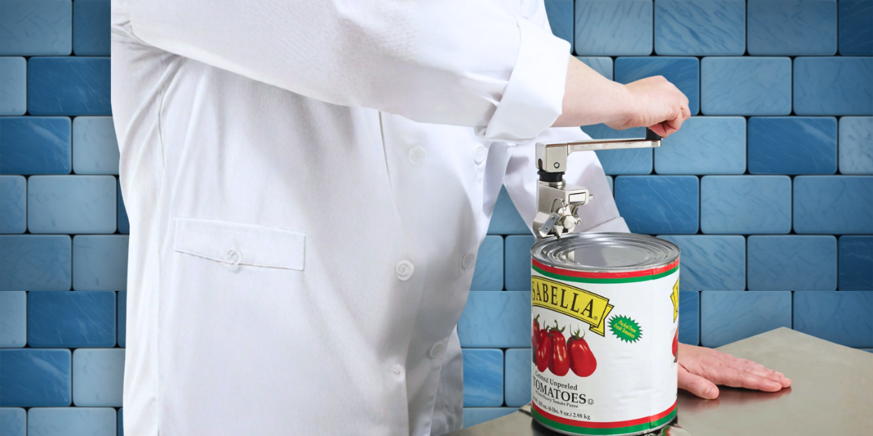 A commercial heavy-duty manual can opener mounted to a stainless steel prep table, being used by a chef to open a large #10 industrial tomato can.