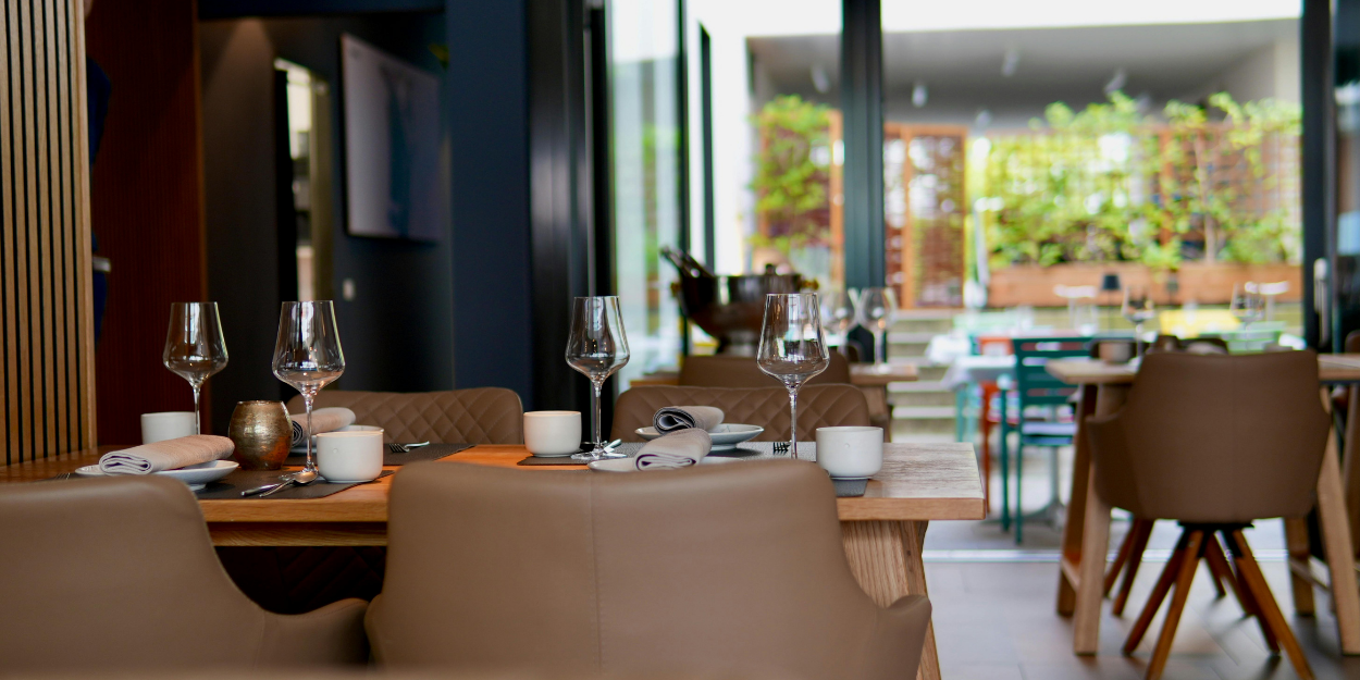 Elegant fine dining table setting in a modern restaurant, featuring high-quality stemware, crisp linen napkins, and contemporary tableware ready for professional service.