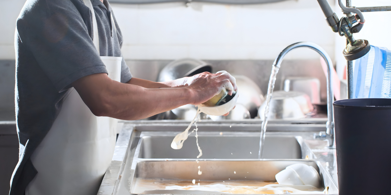 Commercial dishwashing and janitorial cleaning equipment, featuring industrial sink setups and sanitation supplies for restaurant and institutional kitchens.