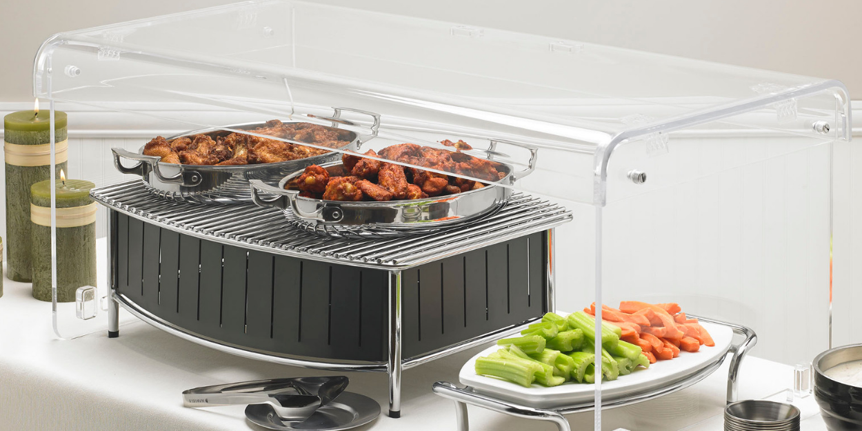 A professional buffet display featuring a modern black induction warmer with a clear acrylic sneeze guard.