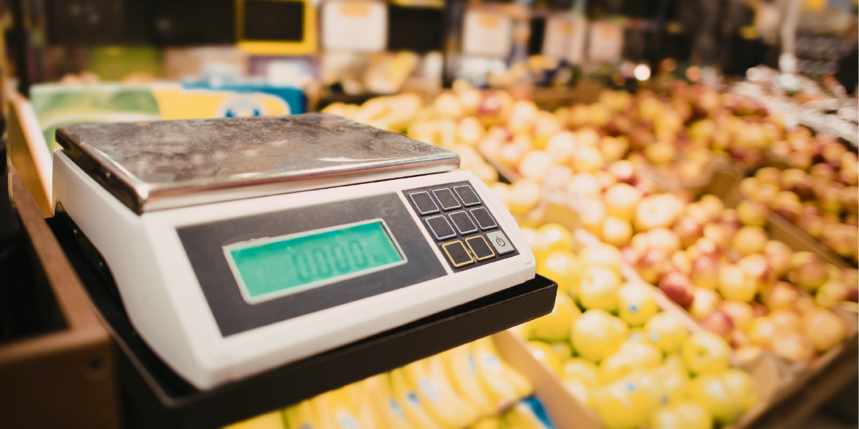 Digital food scales weighing produce in grocery store produce section