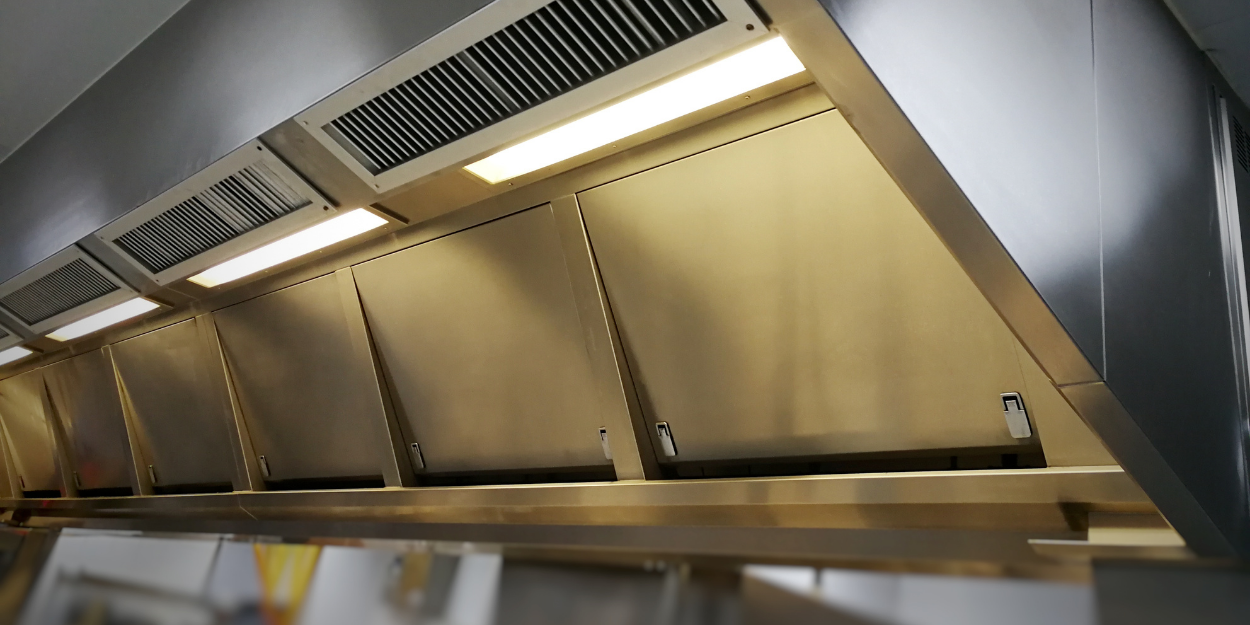 Commercial kitchen hoods and ventilation system above cooking line