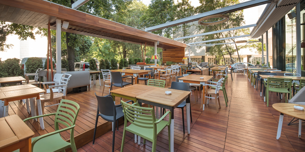 Professional restaurant and outdoor patio furniture collection including commercial-grade tables and stackable chairs, arranged for hospitality and dining service.