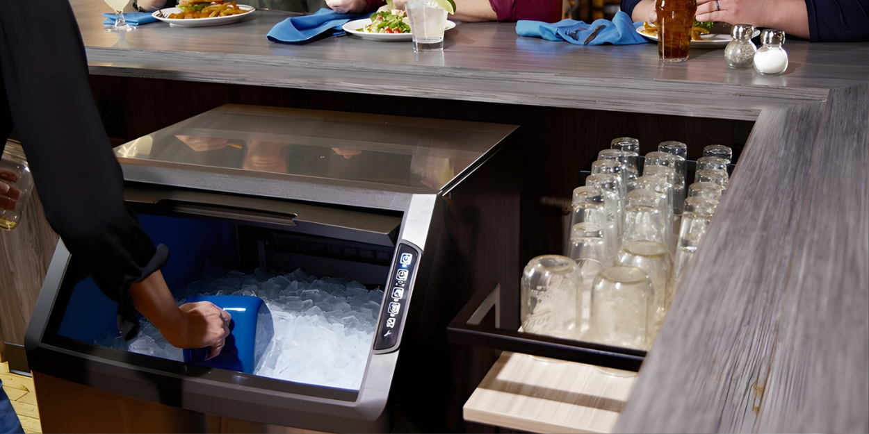 Bar setting with ice machine and stacked glasses on a counter.