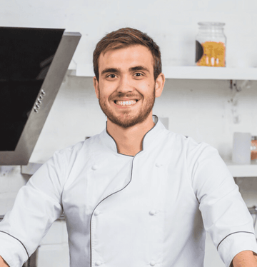 Man in a chef's coat standing in a kitchen