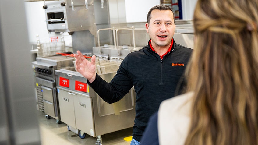 Burkett Sales representative discussing commercial kitchen equipment with customer in showroom