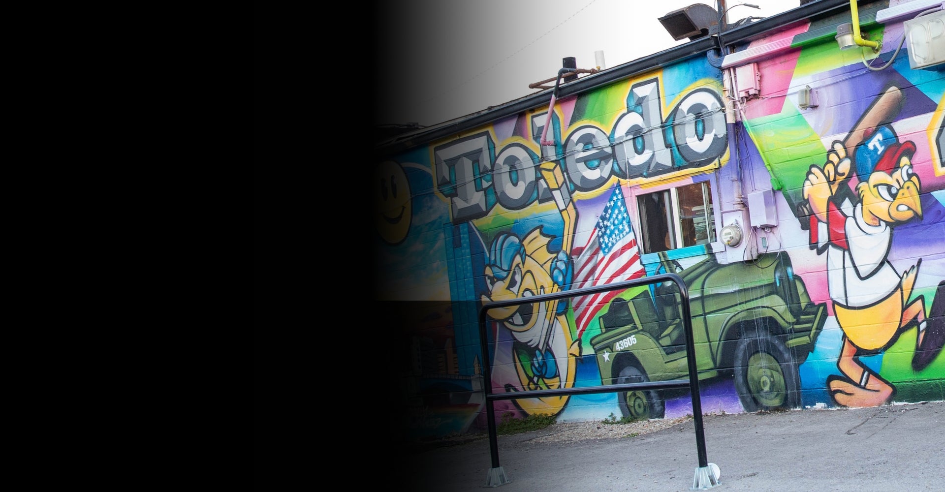 Colorful mural on a wall with cartoon characters and the word 'Toledo'.