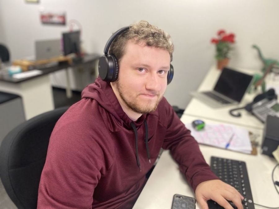 Office employee wearing headset working at computer for customer support and business operations