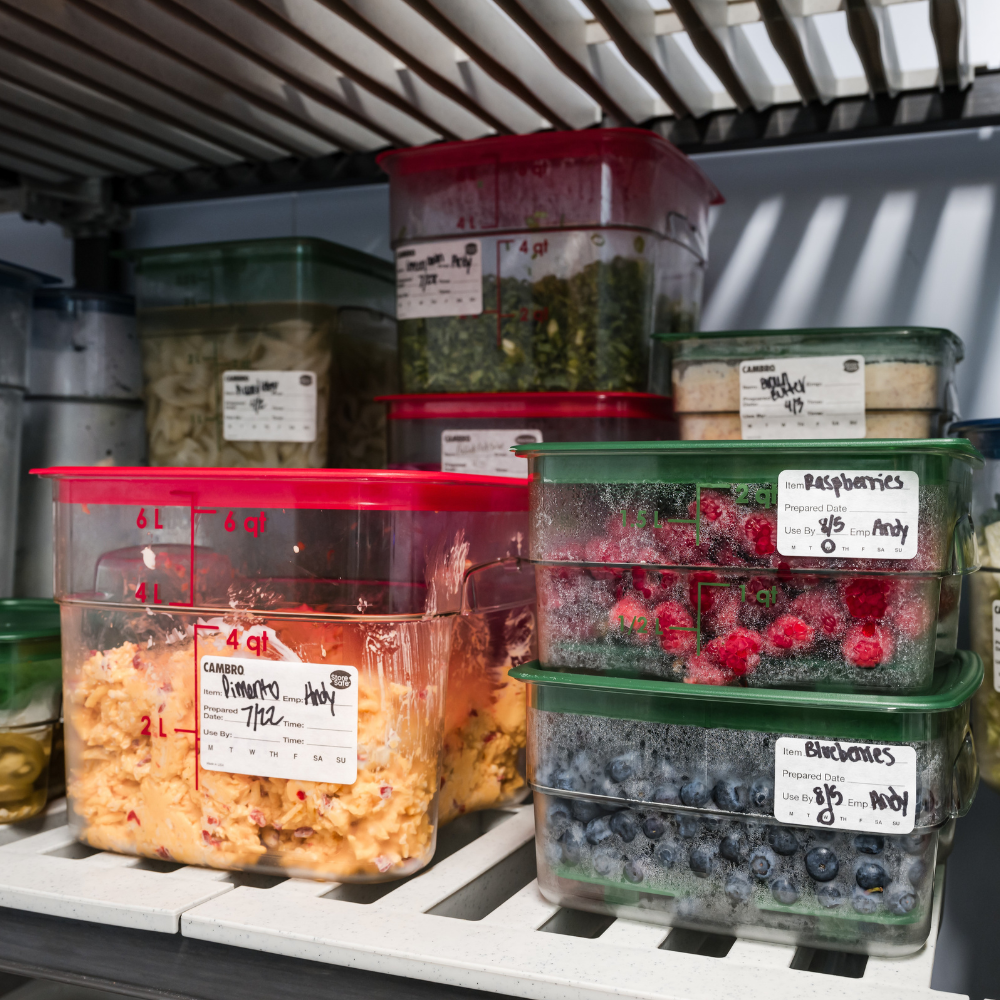 Stacked Cambro food storage containers filled with ingredients