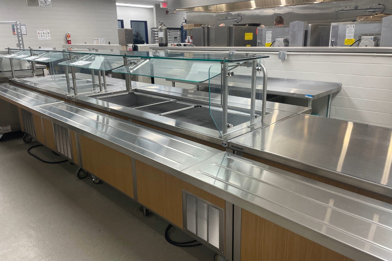 School cafeteria serving line with hot wells and mobile stainless steel serving stations