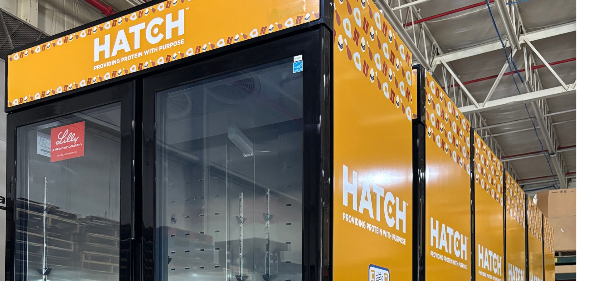 Close-up of yellow HATCH for Hunger custom graphics on a commercial refrigerated merchandiser