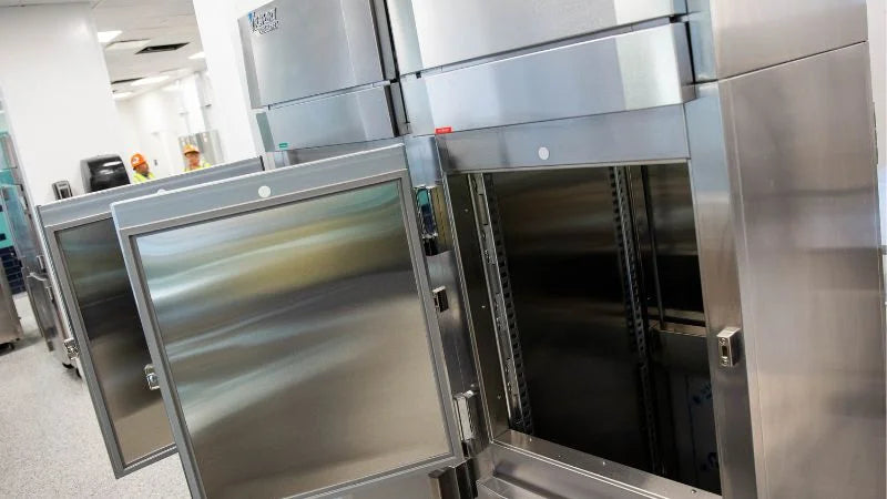 Stainless steel pass-through refrigerators with doors open in commercial kitchen