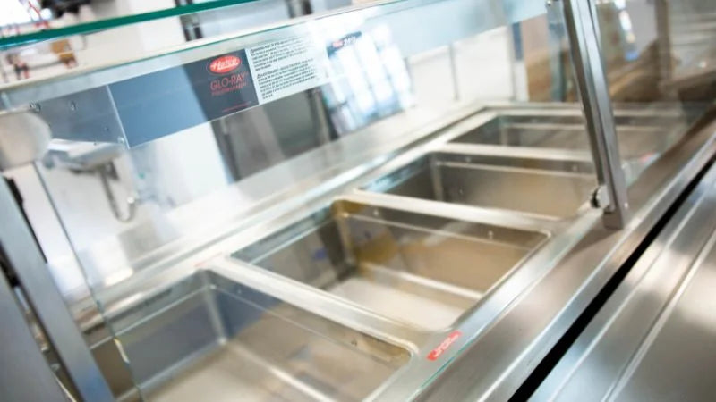 Cafeteria hot food serving line with stainless steel food wells