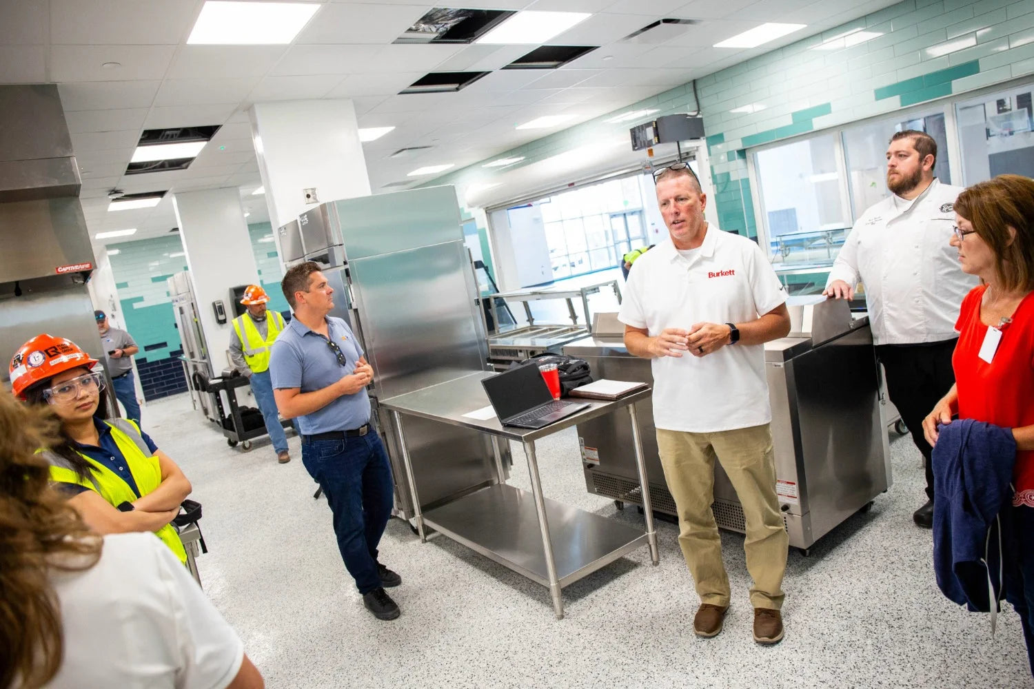 Lake Elementary kitchen with chef, construction workers, and Burkett employees