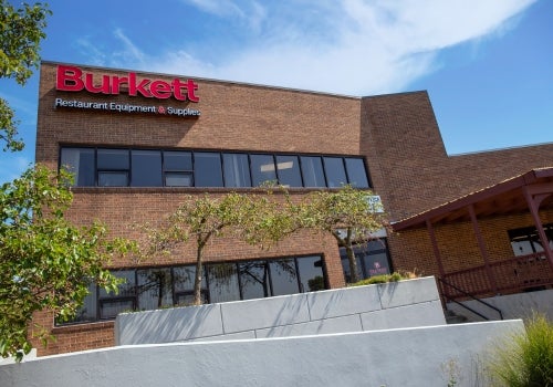 Brick building with 'Burkett' sign against a blue sky