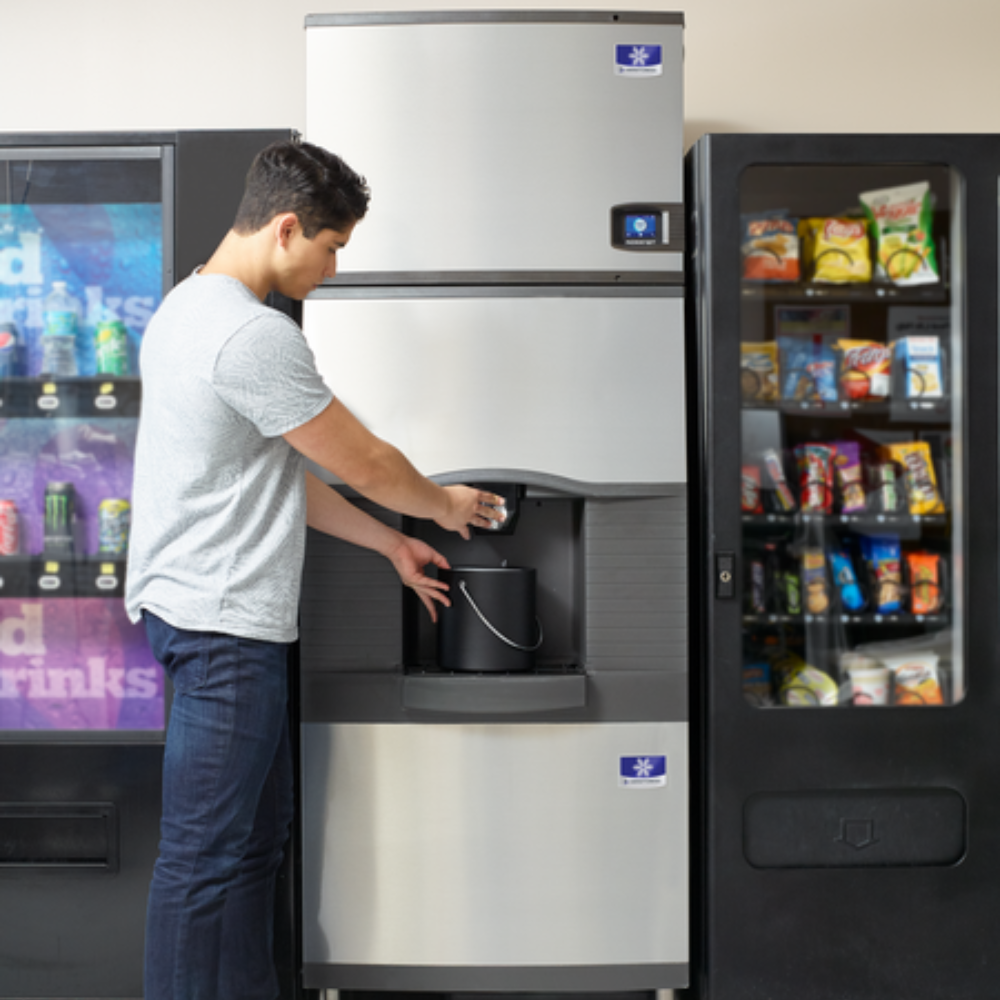 a man filling up an ice bucket using a hotel ice machine