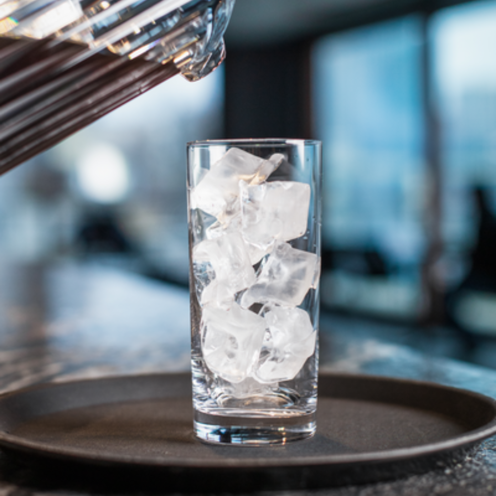 Glass of ice with a pitcher of tea ready to pour inside it