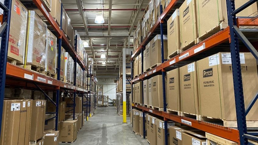 Warehouse aisle with pallet racks stocked with boxed inventory for order fulfillment