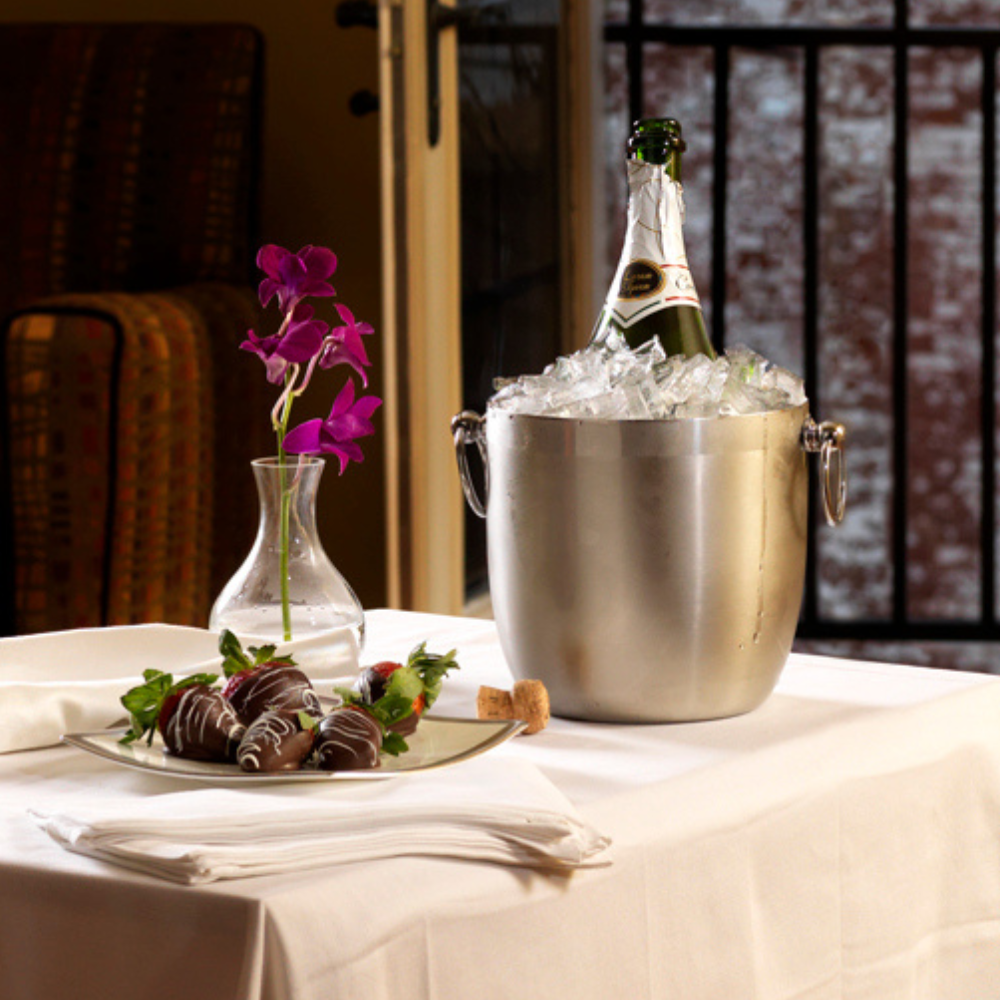 Bottle of champagne in an ice bucket in a hotel room.
