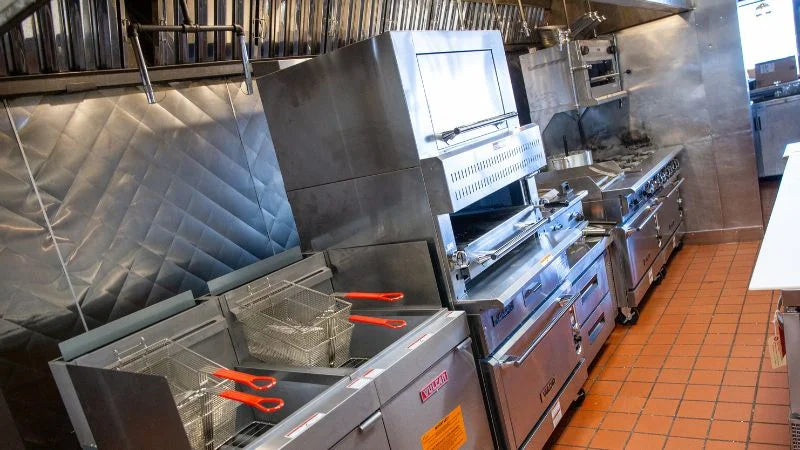Commercial kitchen with stainless steel appliances and tiled floor